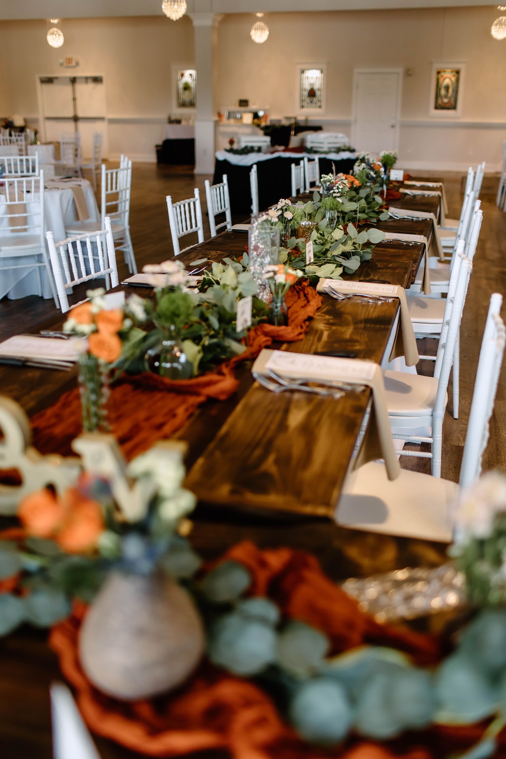 A long wooden table with a vase of flowers on it.