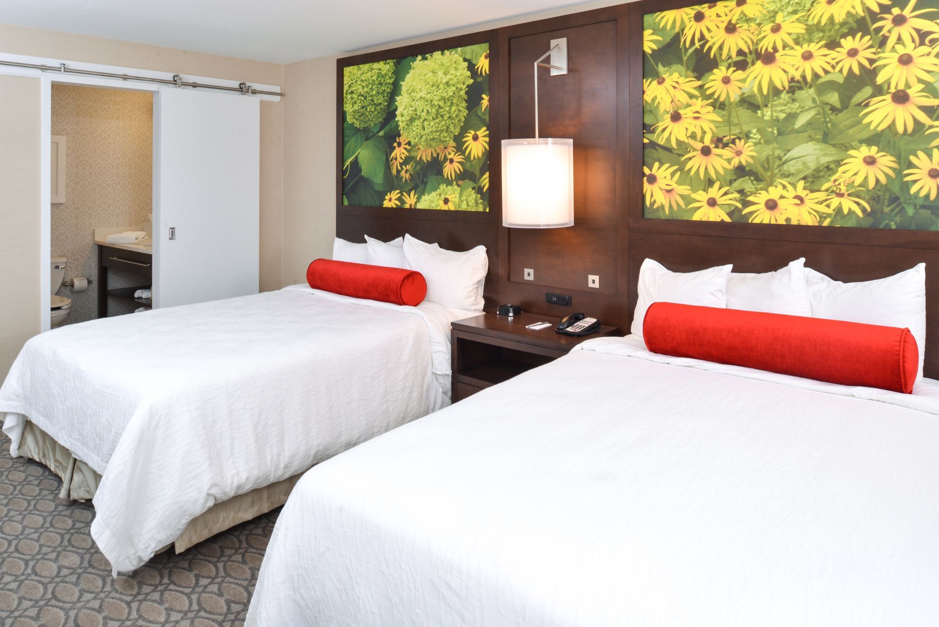 A hotel room with two beds and a painting on the wall.