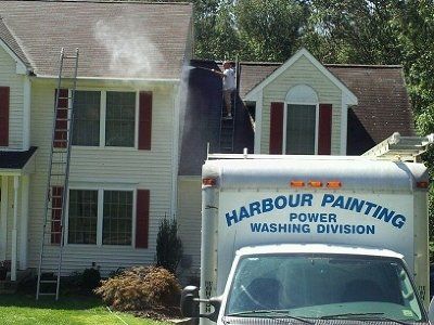 House being power washed by Harbour Painting truck. A ladder leans against the home.