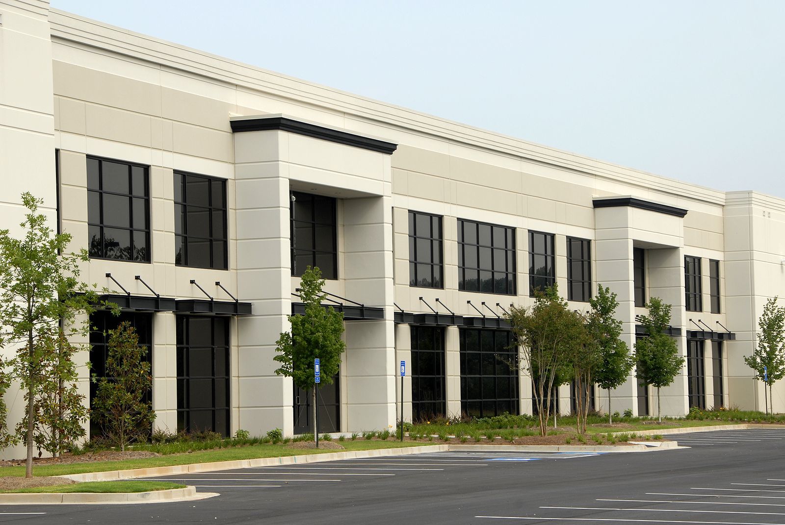 A large building with a lot of windows and a parking lot in front of it