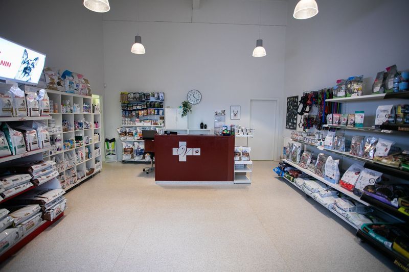 Interior of a veterinary clinic with a reception desk and shelves of pet supplies.