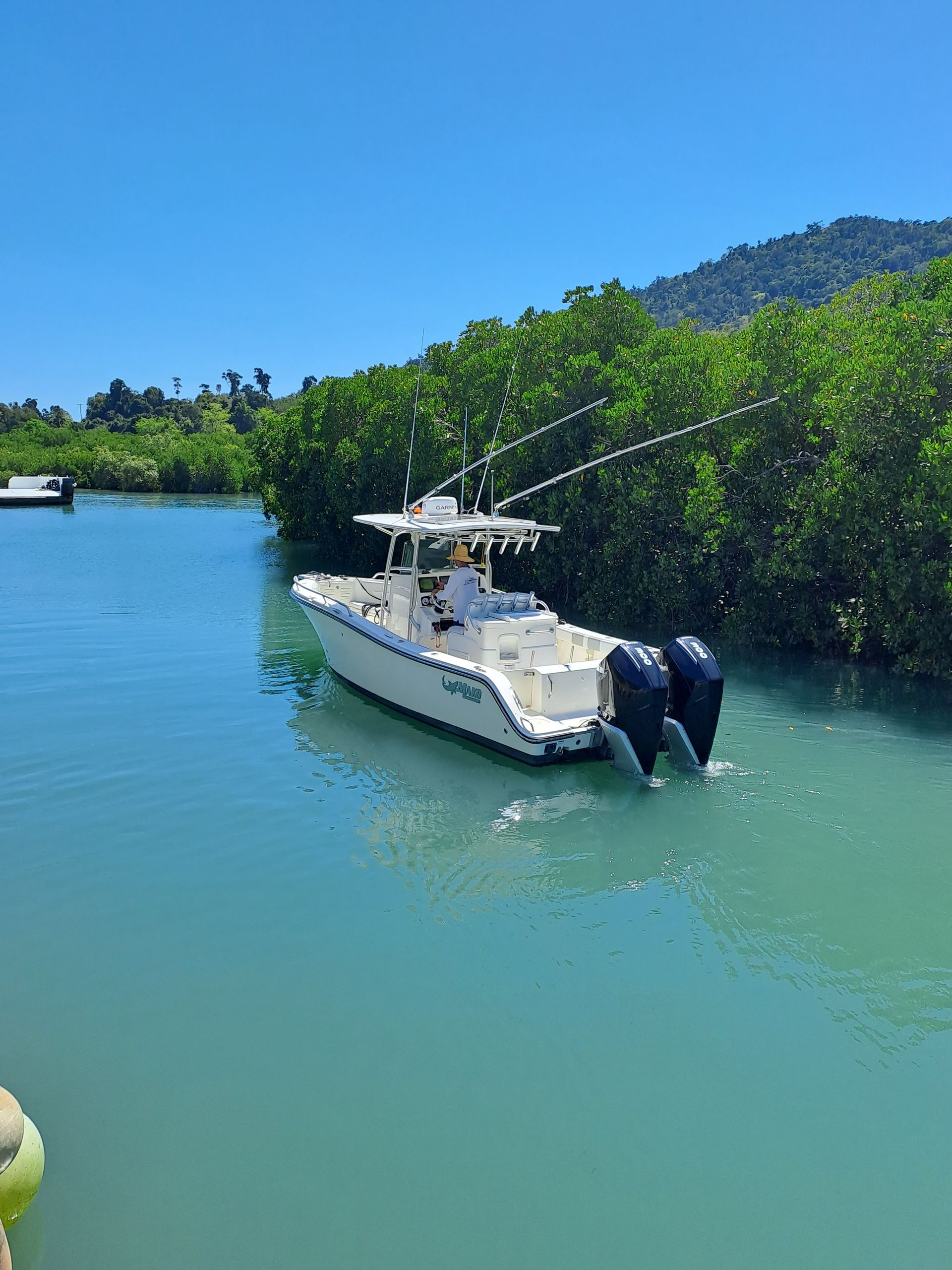 A white boat is floating on top of a body of water — Edge's Boatyard In Jubilee Pocket, QLD