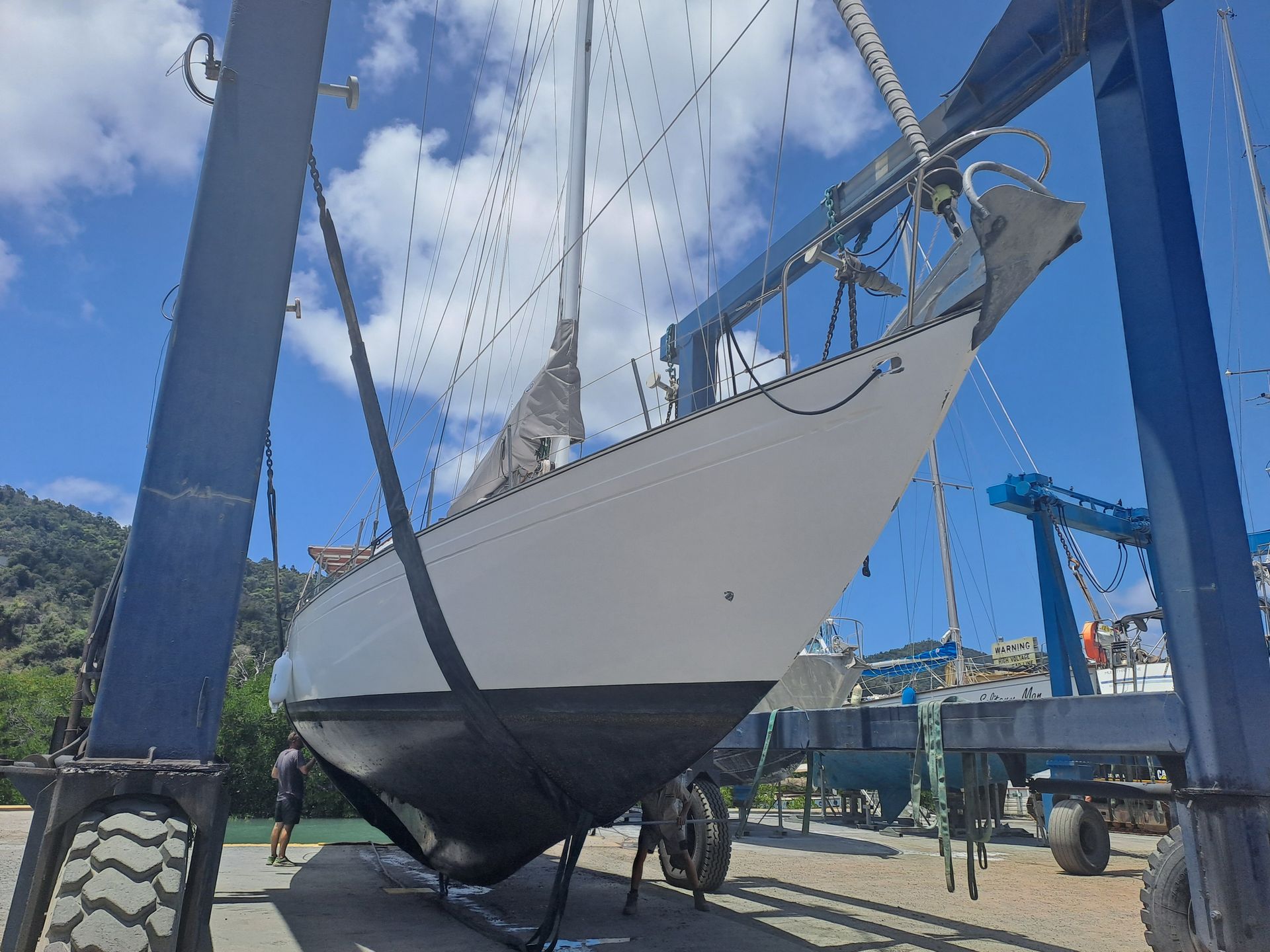 A sailboat is being lifted into the water by a crane — Edge's Boatyard In Jubilee Pocket, QLD