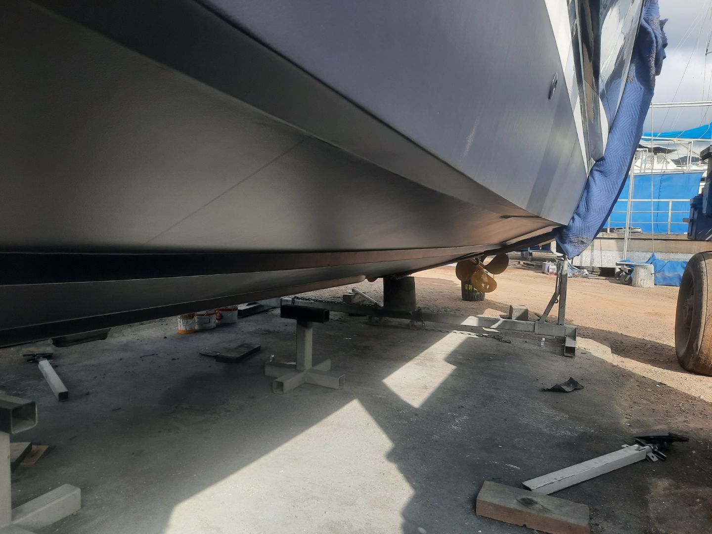 A Man Wearing A Green Apron Is Sandblasting A Boat — Edge's Boatyard In Jubilee Pocket, QLD