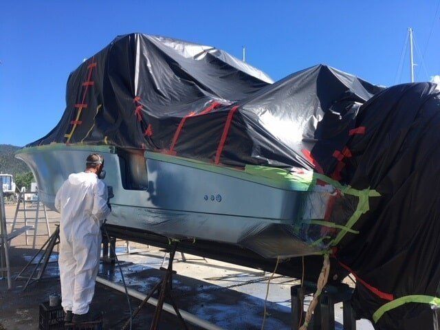 A Man In White Overalls Is Painting A Boat — Edge's Boatyard In Jubilee Pocket, QLD