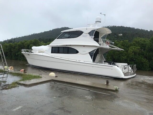 A Large White Boat Is Docked At A Dock On A Rainy Day — Edge's Boatyard In Jubilee Pocket, QLD