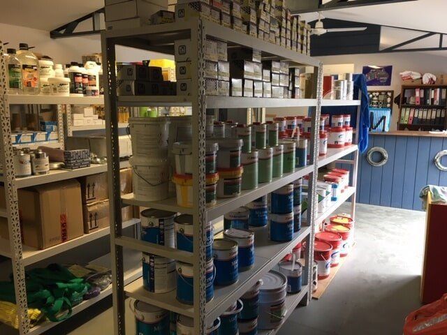 A Store Filled With Shelves Filled With Lots Of Paints — Edge's Boatyard In Whitsundays, QLD