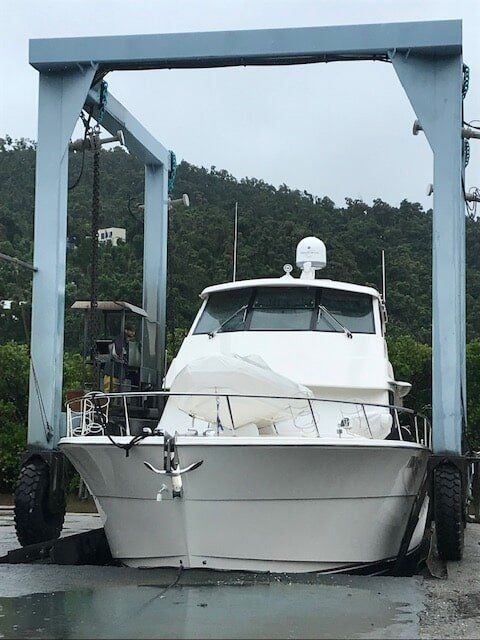 A Large White Boat Is Being Lifted By A Crane — Edge's Boatyard In Jubilee Pocket, QLD
