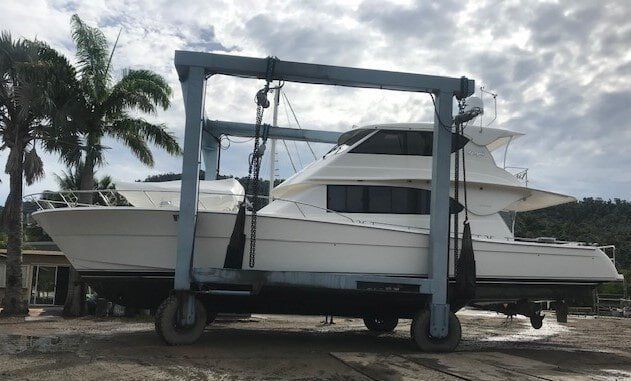 A Boat Is Being Lifted By A Crane In A Marina — Edge's Boatyard In Jubilee Pocket, QLD