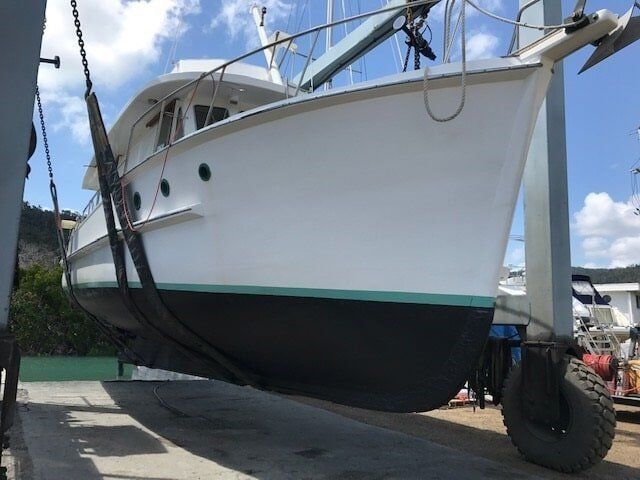 A Large White Boat Is Being Lifted By A Crane — Edge's Boatyard In Jubilee Pocket, QLD
