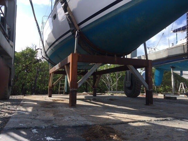 A Blue And White Boat Is Sitting On A Wooden Stand — Edge's Boatyard In Jubilee Pocket, QLD