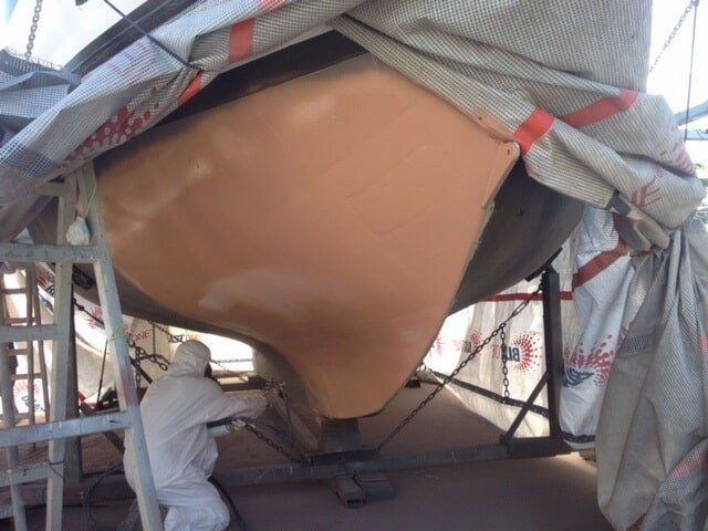 A Man In A Protective Suit Is Working On A Boat — Edge's Boatyard In Jubilee Pocket, QLD