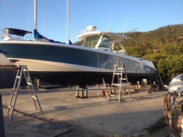 A Boat Is Sitting On A Concrete Dock With A Ladder Next To It — Edge's Boatyard In Jubilee Pocket, QLD