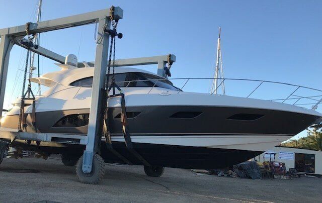 A Large Boat Is Being Lifted By A Crane — Edge's Boatyard In Airlie Beach, QLD