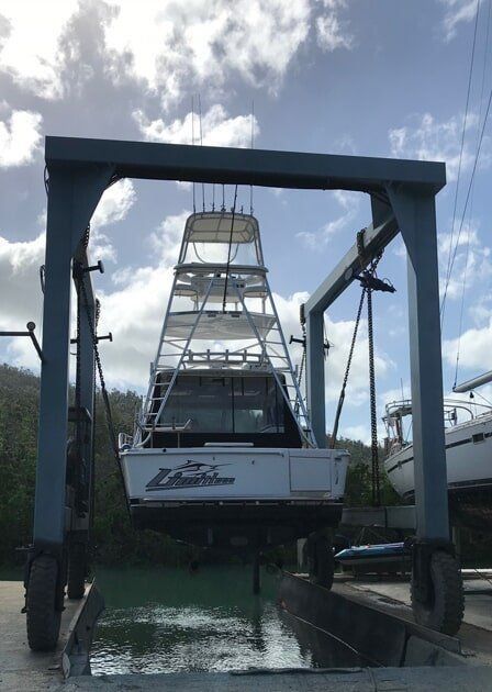 A Boat Is Being Lifted Into The Water By A Crane — Edge's Boatyard In Jubilee Pocket, QLD