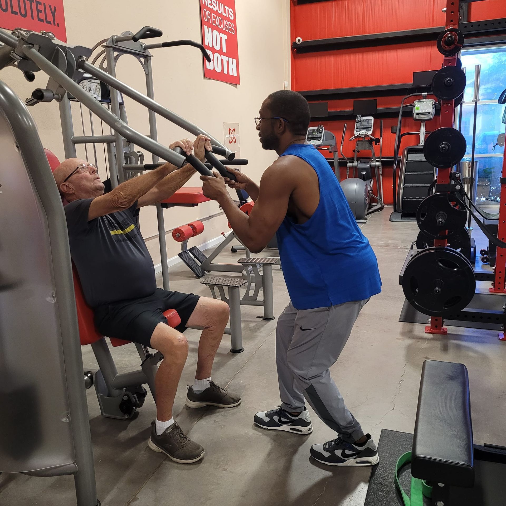Two men are working out in a gym with a sign on the wall that says not loud