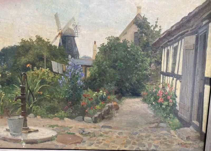 Quiet cottage garden path with flowers, a windmill, and half-timbered houses in soft sunlight