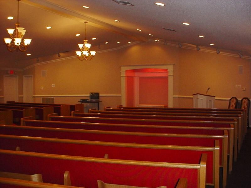 an empty church with red benches and a podium