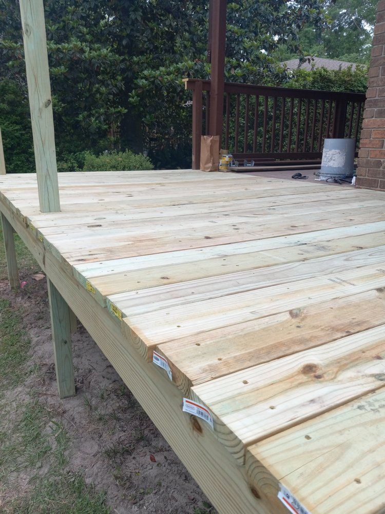 Newly built wooden deck with unfinished planks and railings outdoors