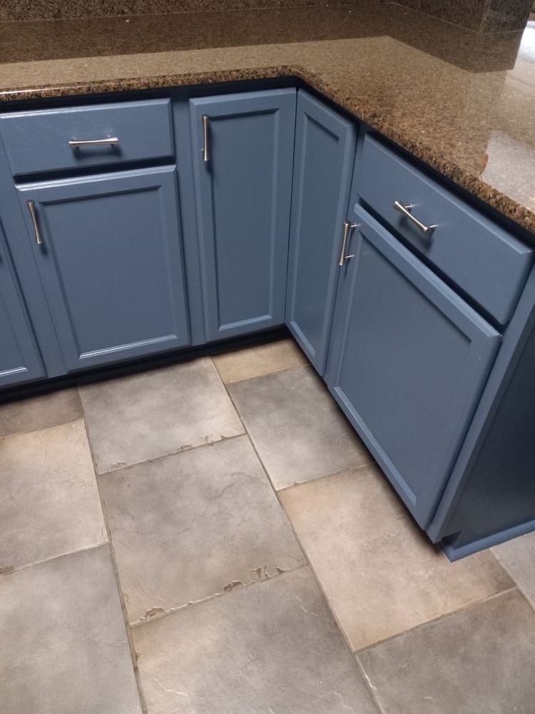 Blue kitchen cabinets with gray tile floor in a corner countertop area