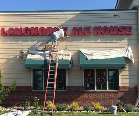 Worker Painting the Exterior of Store — Cherry Hill, NJ — Zach’s Precise Painting