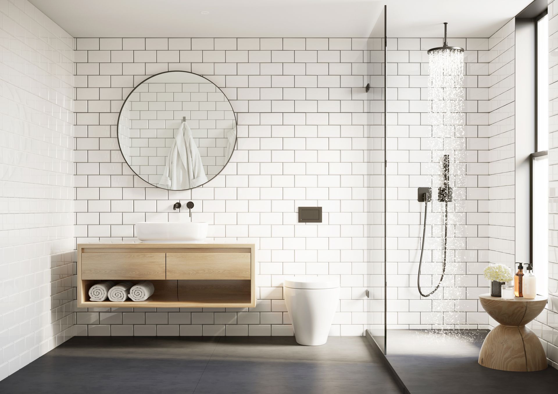 Modern bathroom with white subway tile, round mirror, and wooden vanity. Shower is running.