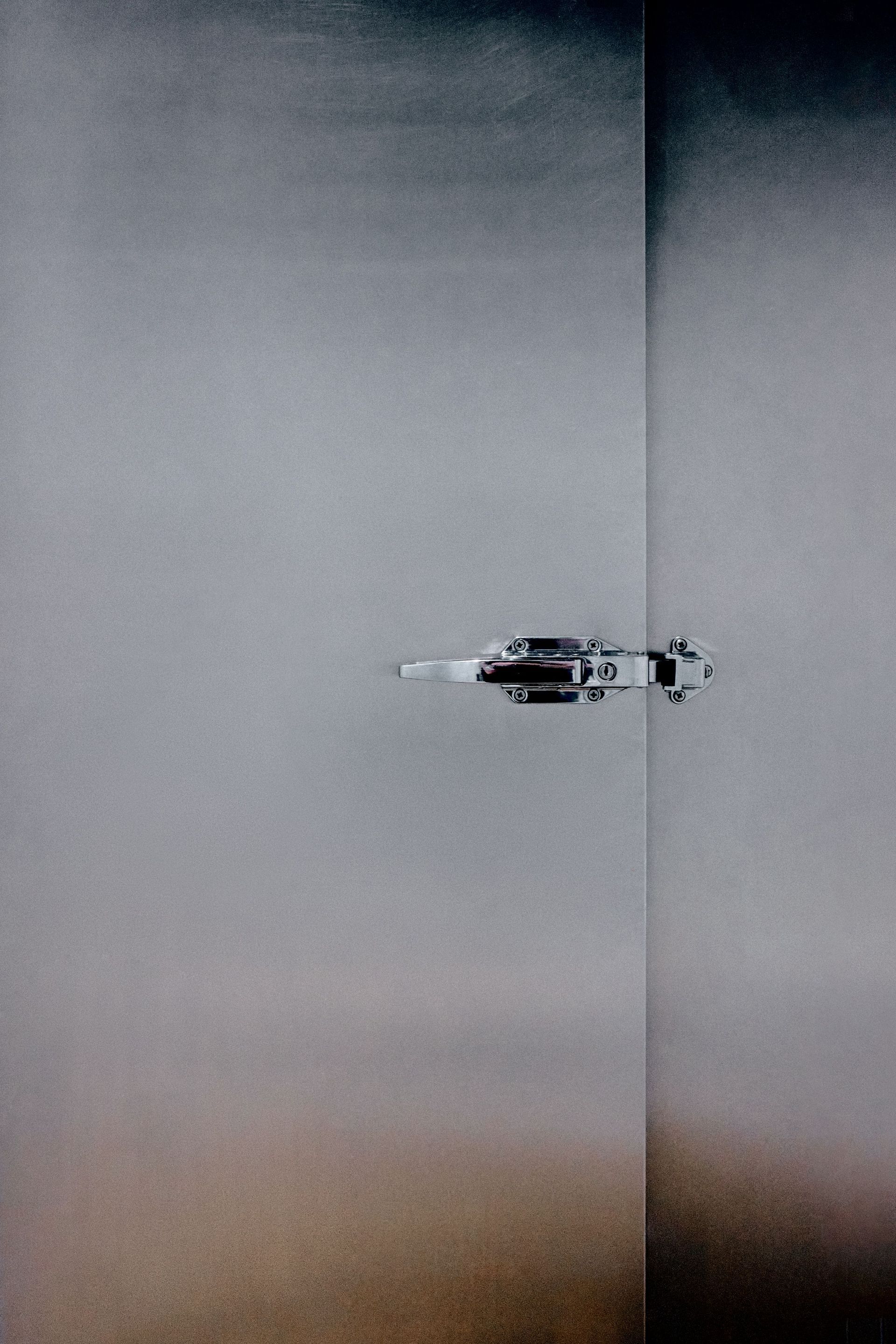 Small helicopter hovering against a gray sky, with a faint brown horizon at the bottom.