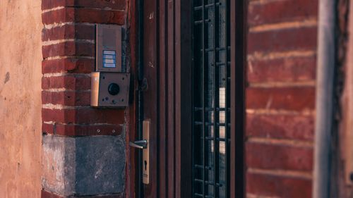 Brick building entrance with an intercom and metal security door