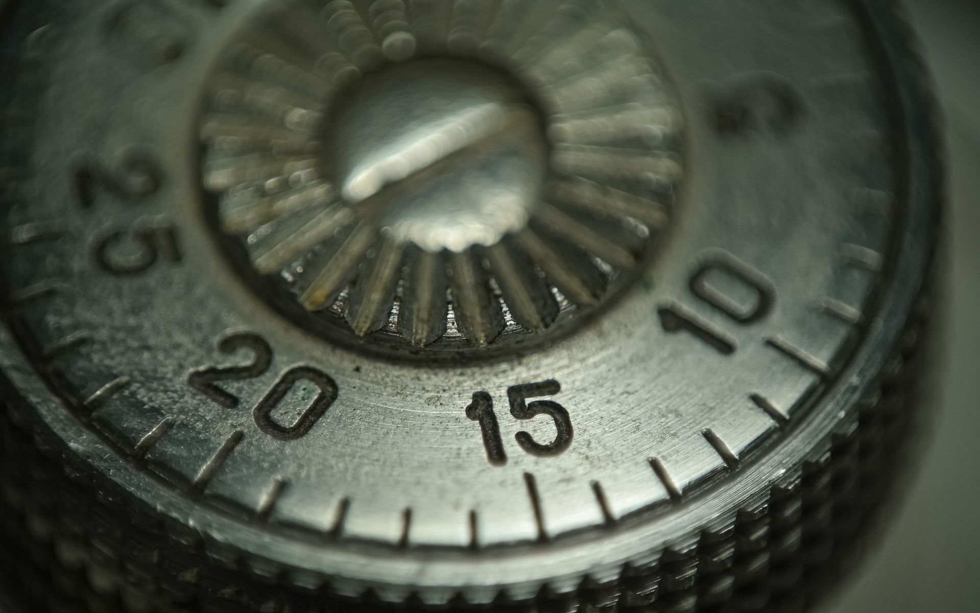 Close-up of a metal combination lock dial with numbers and a central knob
