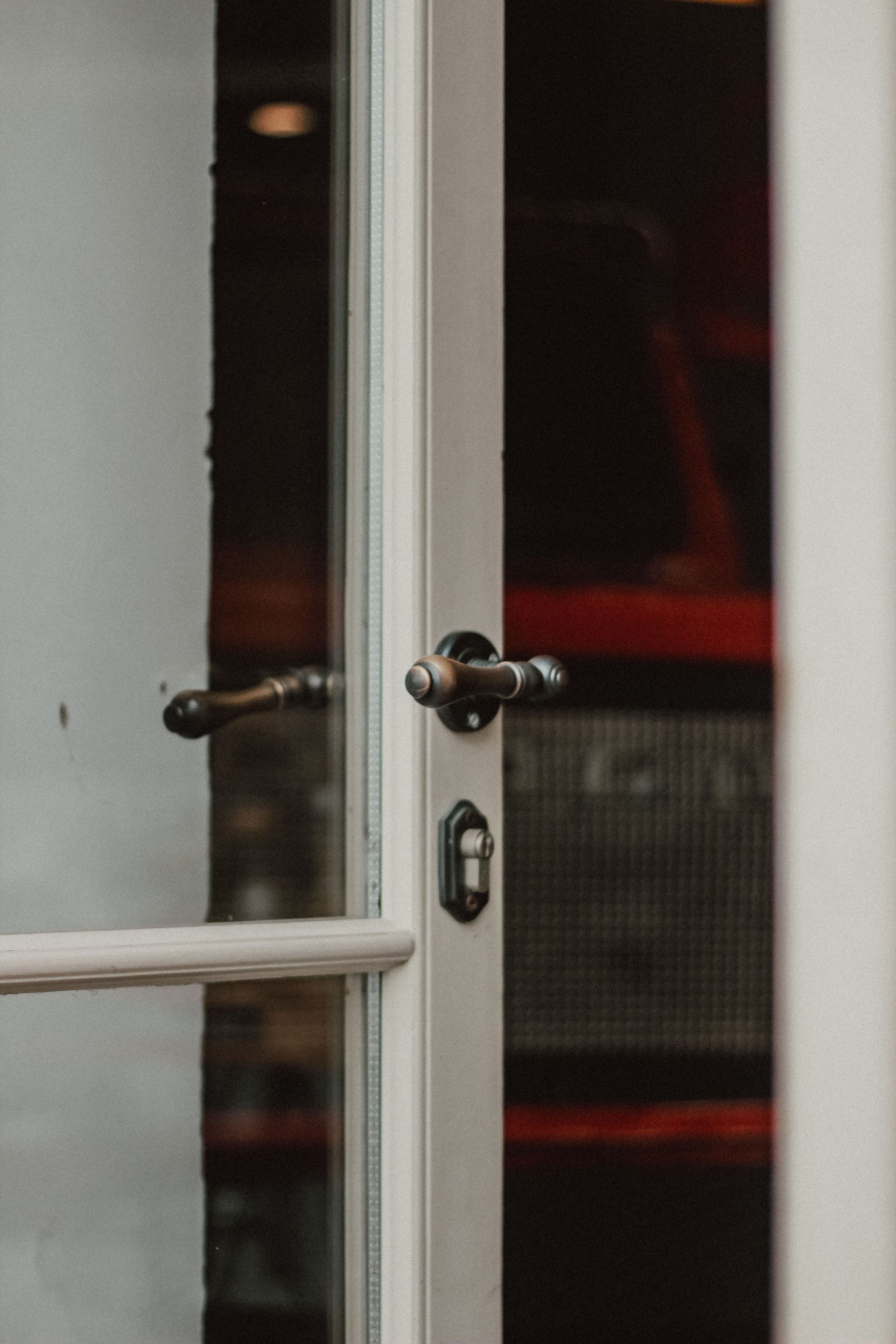 Partially open glass door with a chrome handle and red-lit interior behind it
