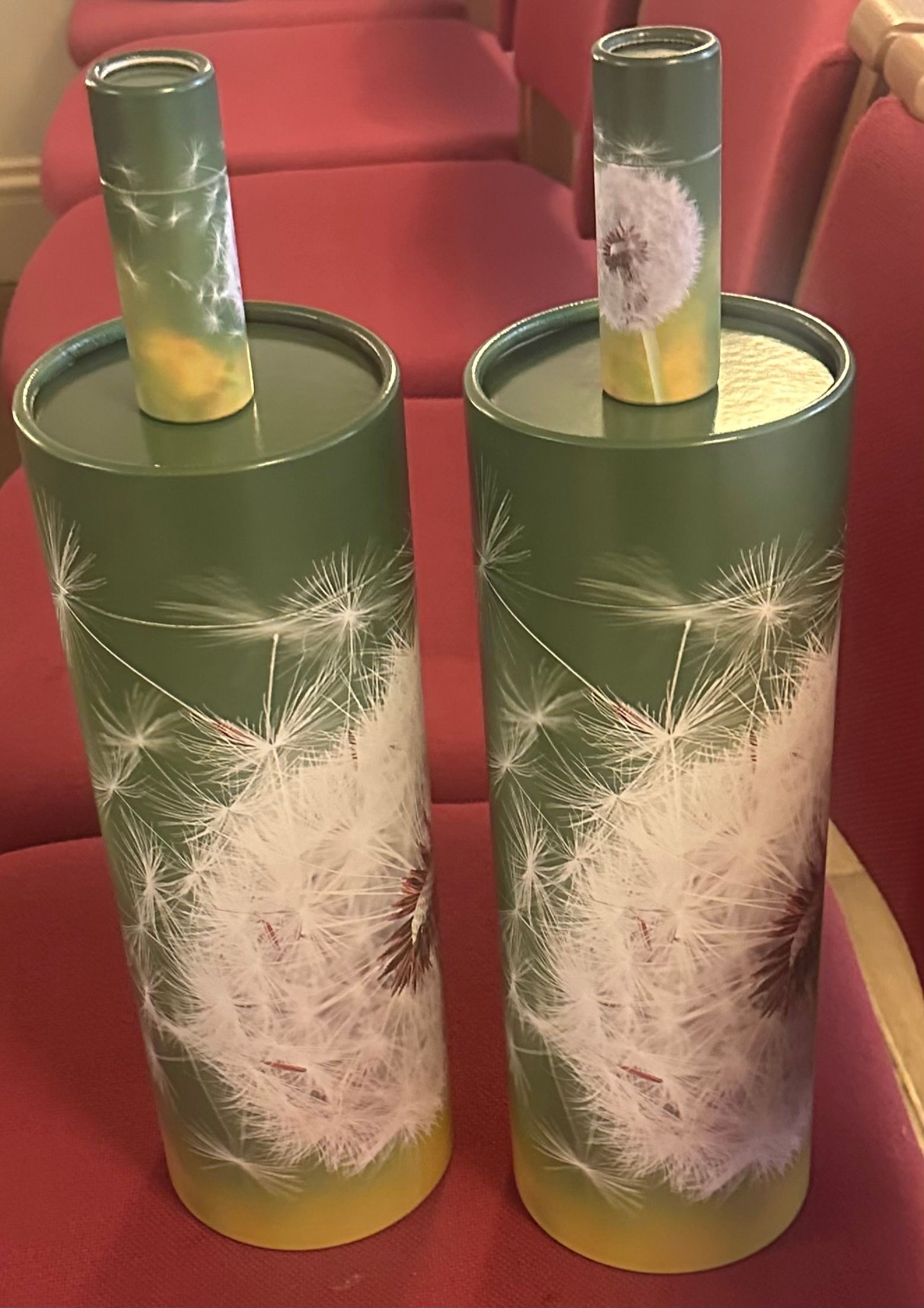 Two green spray-painted bottles with white snowflake patterns on a table, each with a green tube inserted.