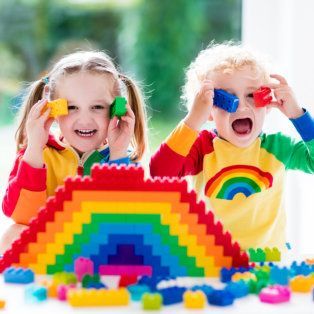 Two children playing with colorful building blocks and a rainbow structure