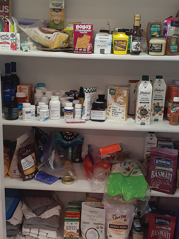 Pantry shelves filled with various food items including packaged goods, liquids, and supplements.