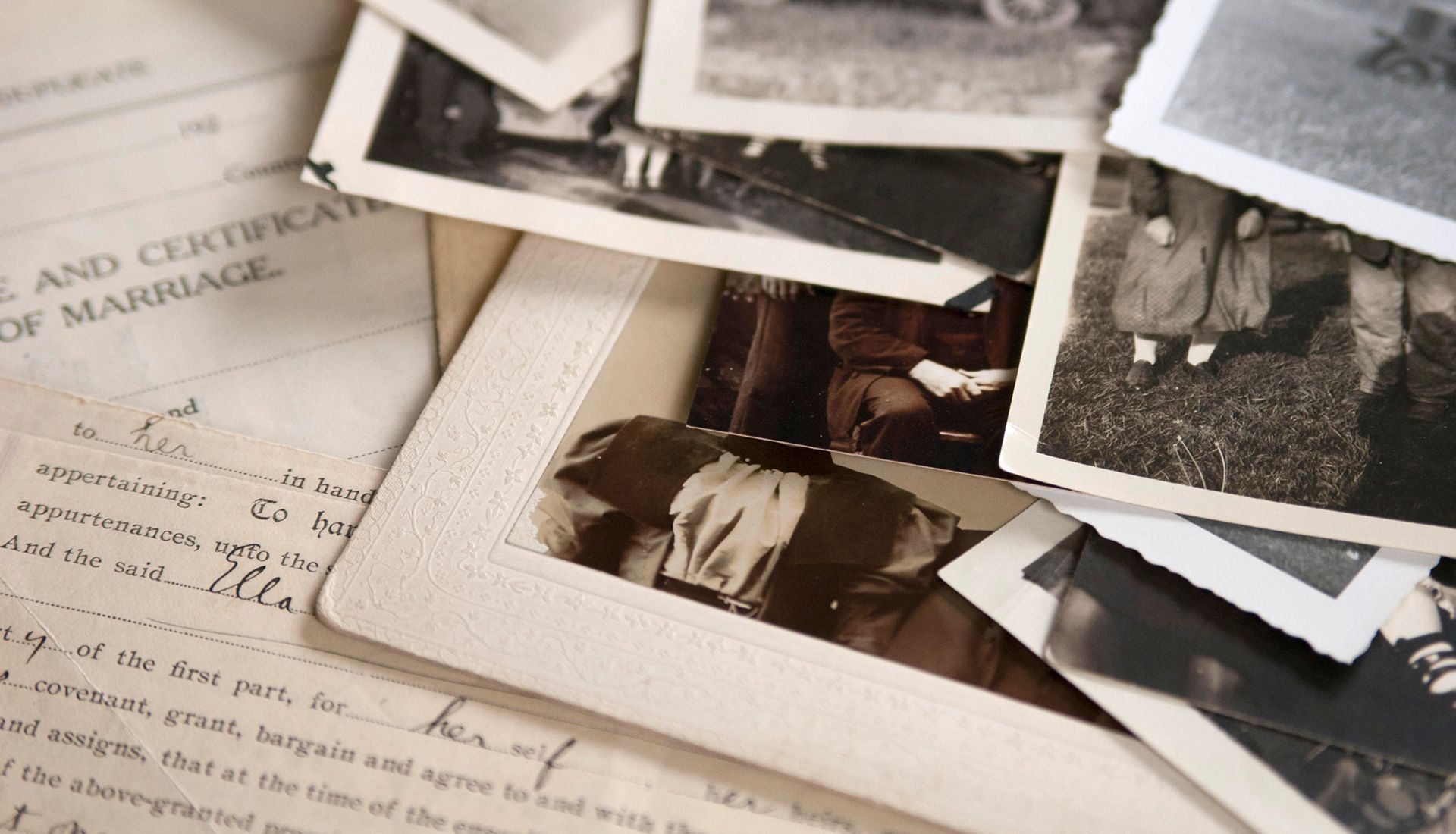 Pile of vintage photographs and documents, including a marriage certificate.
