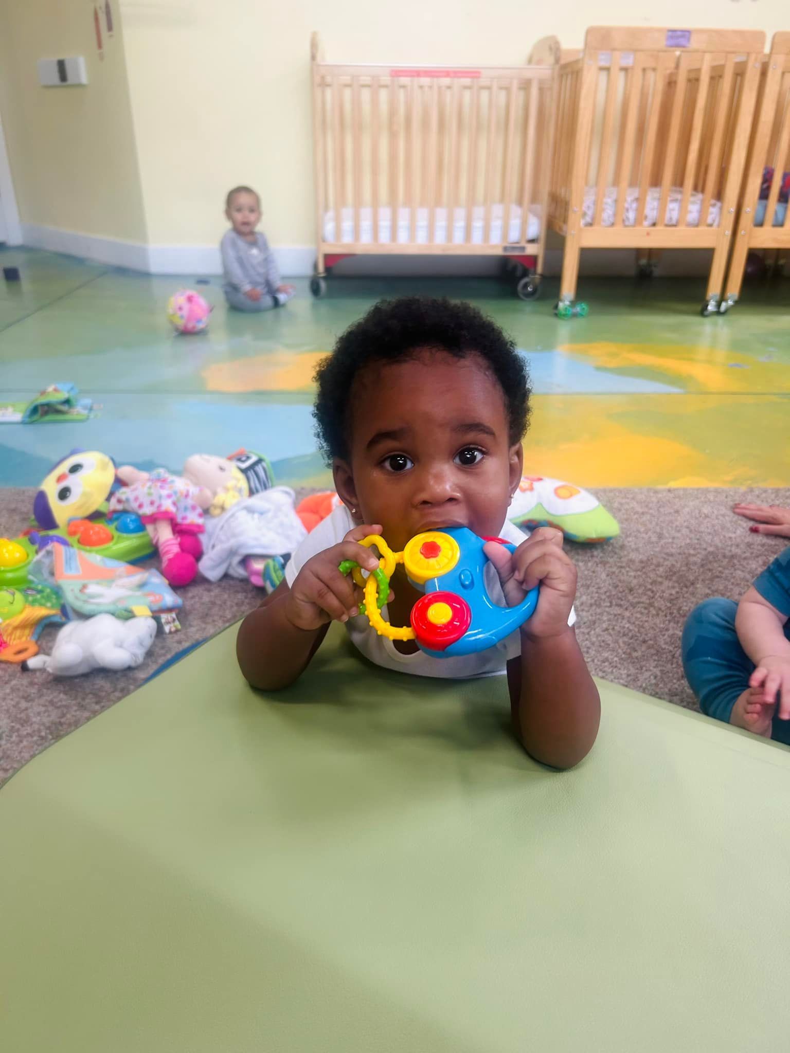 A group of women and children are sitting at a table playing with blocks.