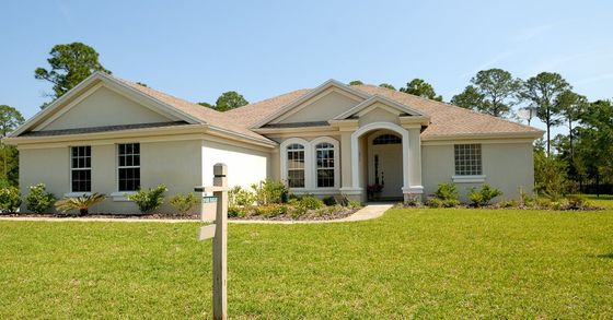 A house with a for sale sign in front of it.