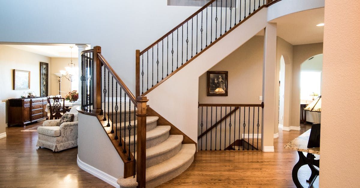 A staircase in a house with a wooden railing leading up to the second floor.