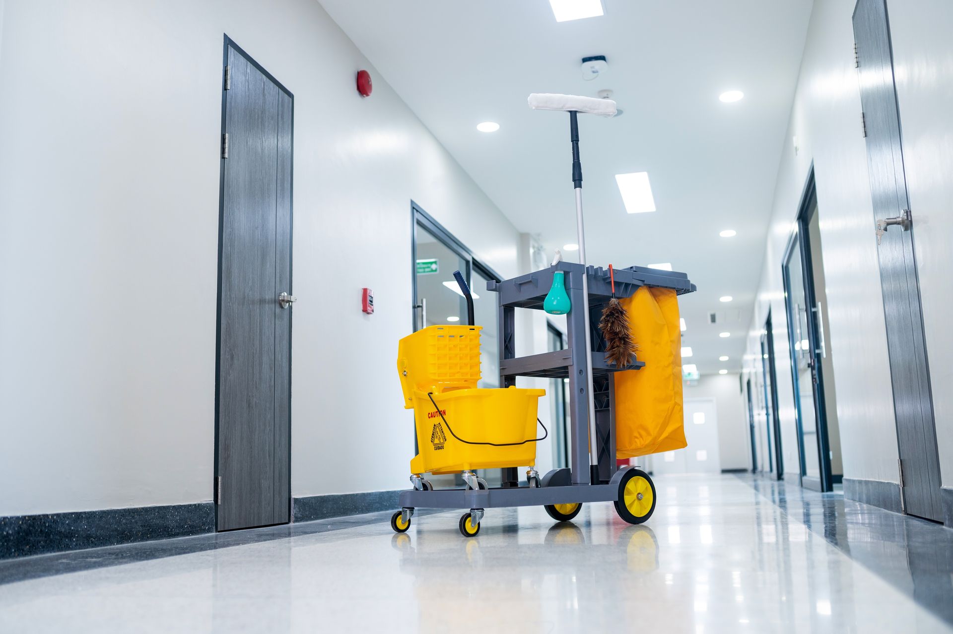 Un chariot de nettoyage est garé dans un couloir d'un immeuble.