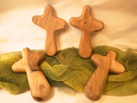 Three wooden crosses are sitting on a green cloth.