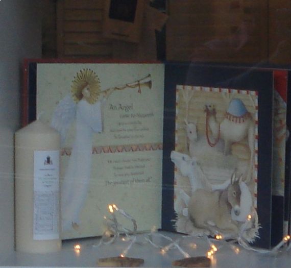 A candle sits next to a picture of an angel blowing a trumpet