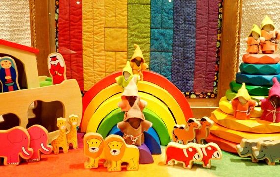 A bunch of wooden toys with a rainbow in the background