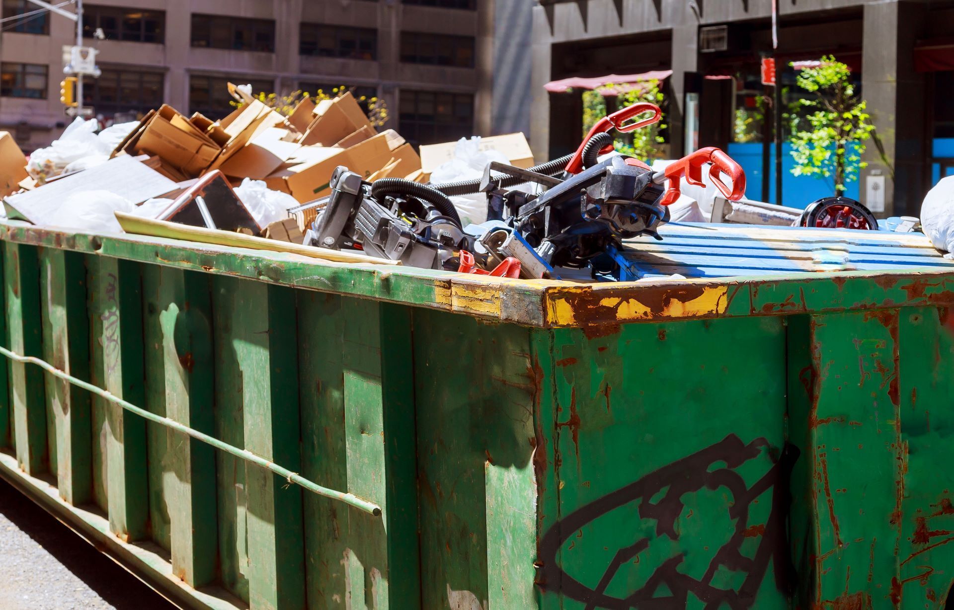 A green dumpster filled with a lot of garbage