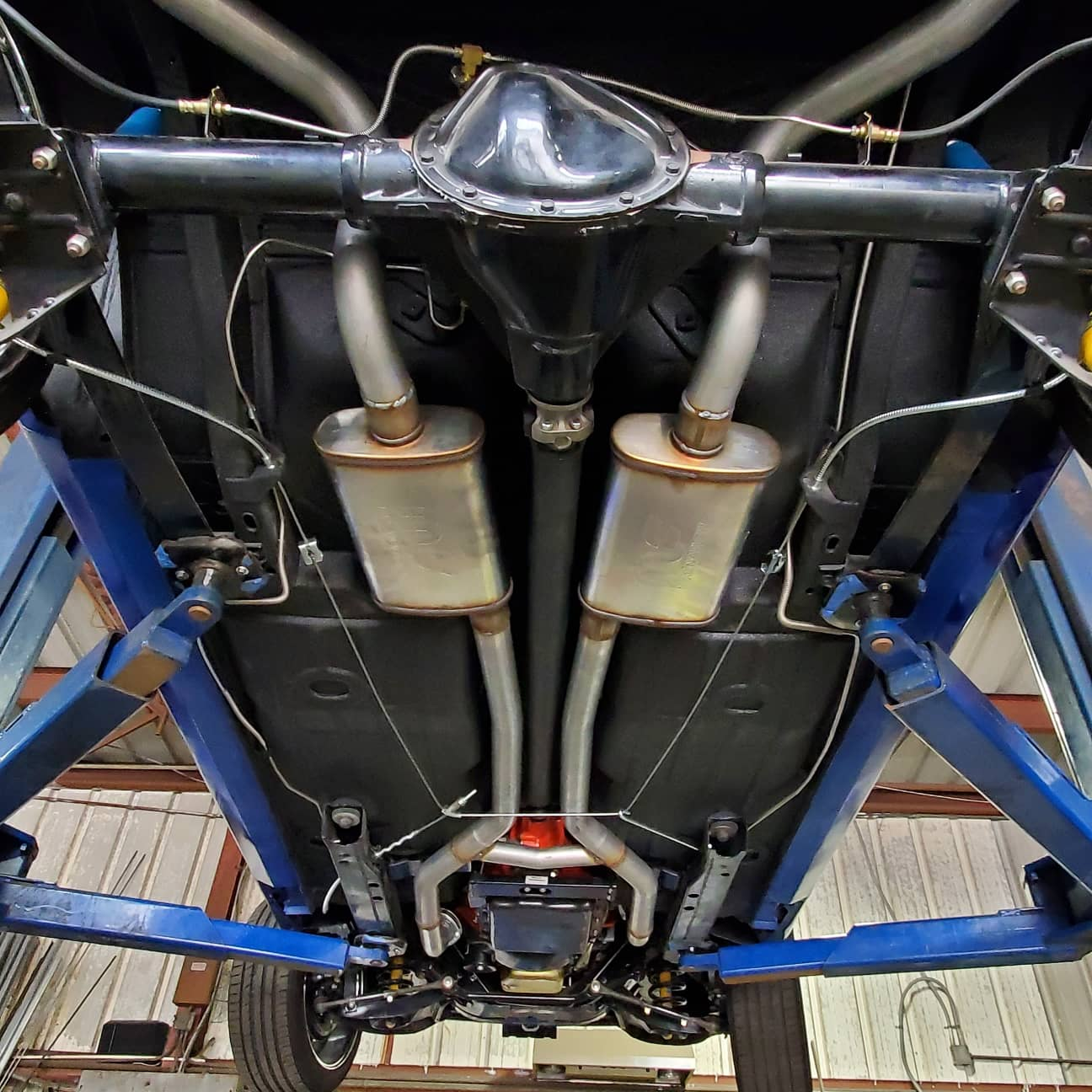 The exhaust pipes of a car are visible underneath it. | Kirk's Radiator & Auto A/C Inc.
