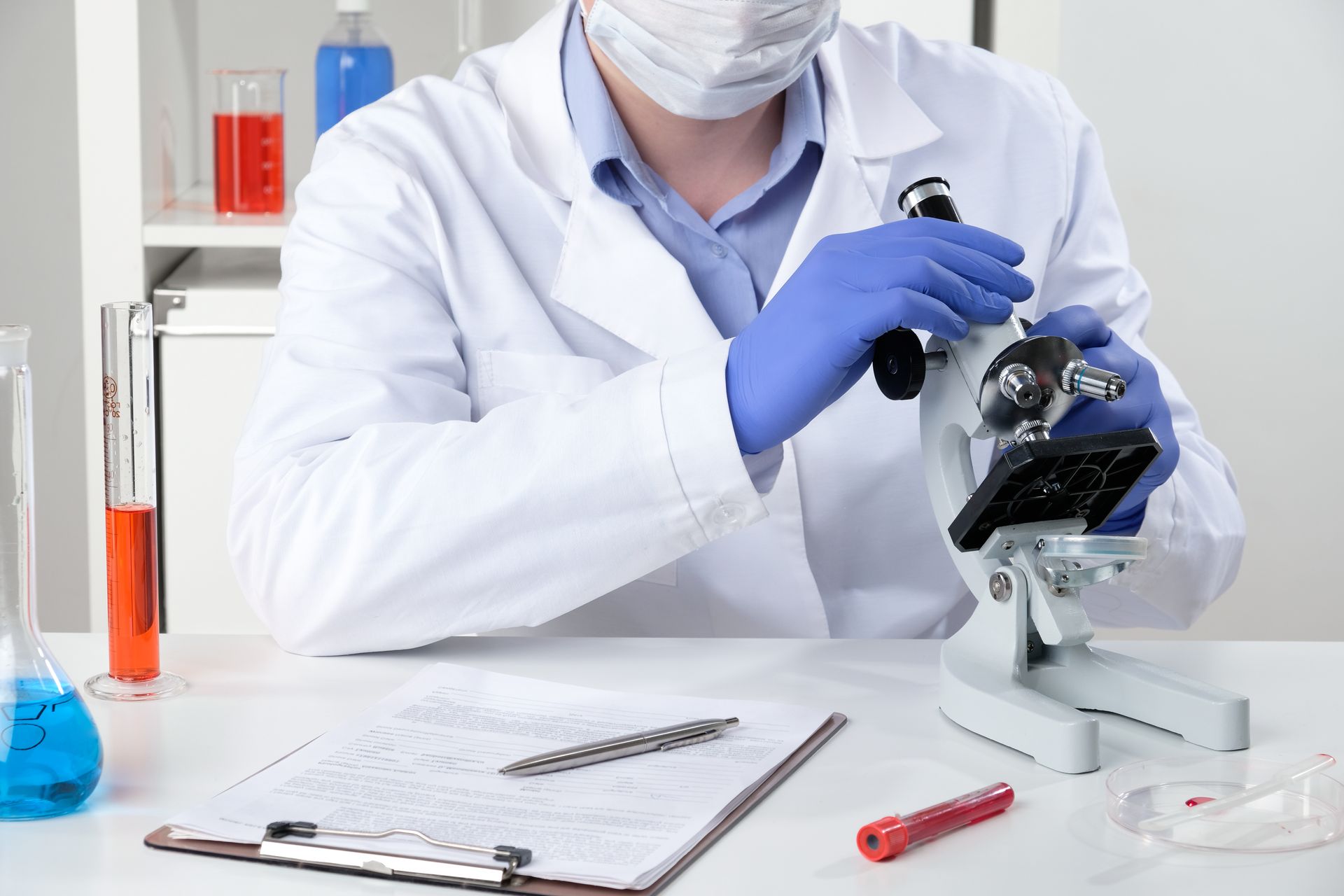 Uno scienziato guarda al microscopio in un laboratorio.