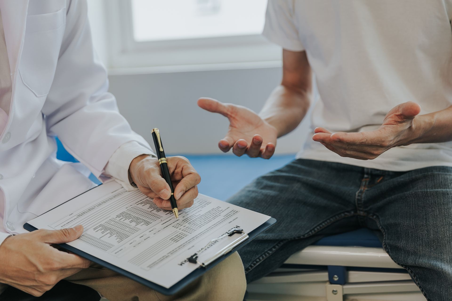 Un medico scrive sugli appunti mentre parla con un paziente.