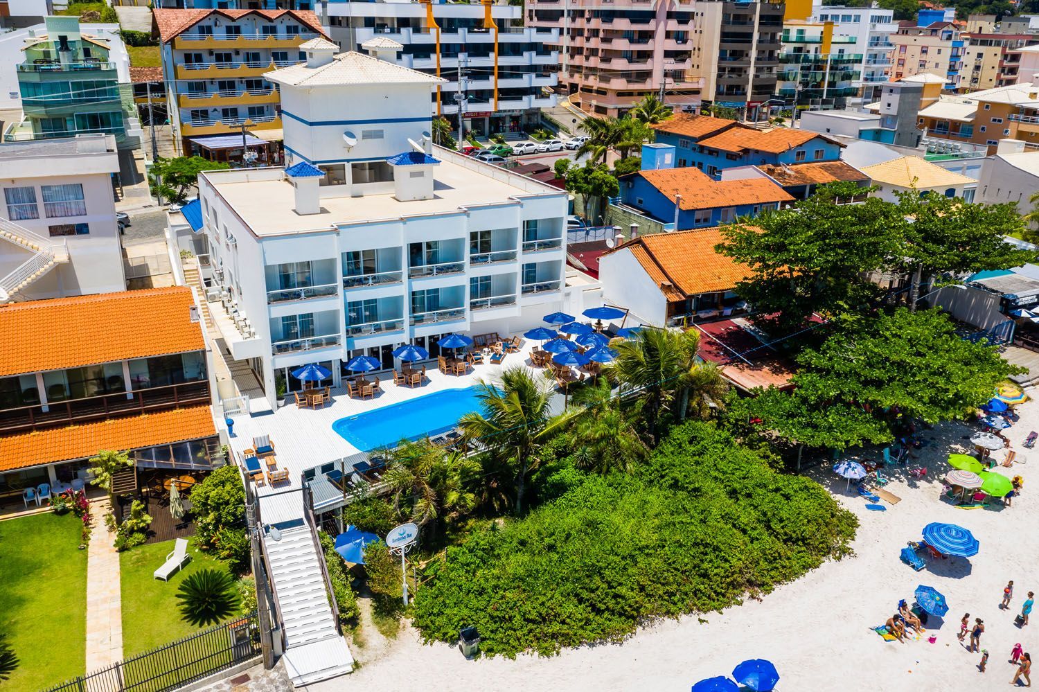 Uma vista aérea de um hotel e uma praia com guarda-sóis.