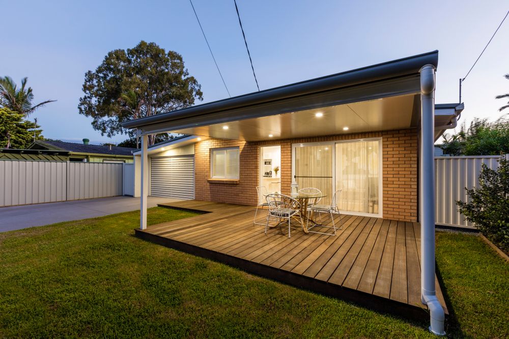 A House With a Wooden Deck and a Table and Chairs on It — Byron Bay Carpentry and Construction In Suffolk Park, NSW