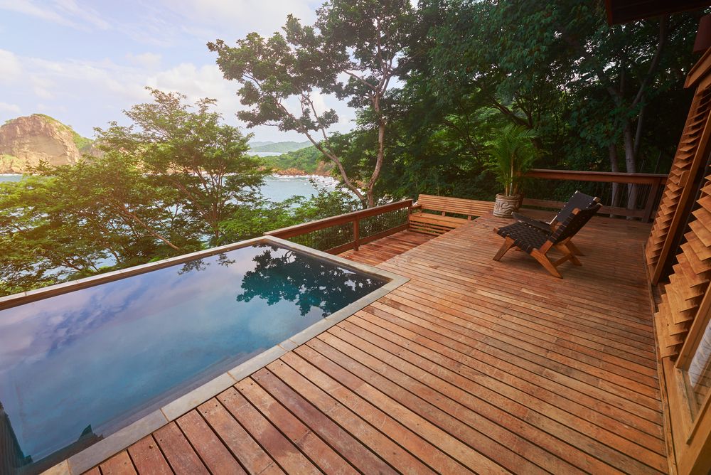 A Wooden Deck With a Swimming Pool in the Background — Byron Bay Carpentry and Construction In Ballina, NSW