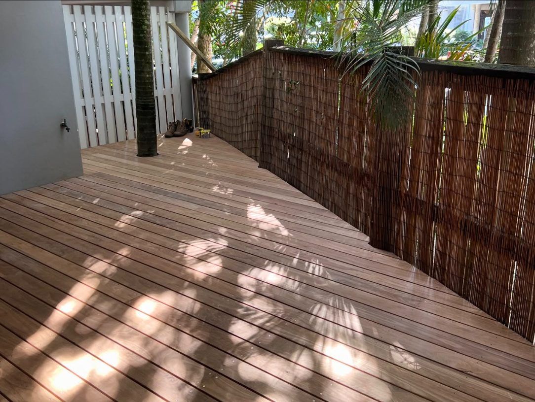 A deck with straw-like fence surrounds by trees— Byron Bay Carpentry and Construction In Suffolk Park, NSW