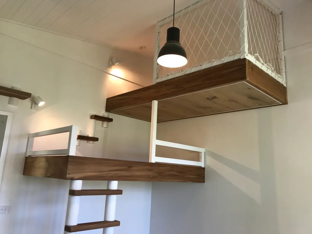 A Bedroom With a Loft Bed and a Ladder — Byron Bay Carpentry and Construction In Suffolk Park, NSW